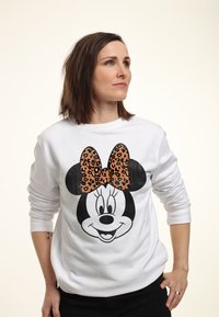 Sudadera blanca con un gran gráfico de Minnie Mouse y un lazo de estampado de leopardo. Mangas largas, material suave, corte holgado.