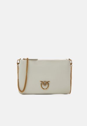 Piccola borsa rettangolare in pelle beige chiaro con tracolla a catena dorata e emblema di uccello dorato sul davanti, chiusura superiore con cerniera.