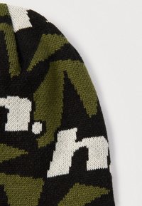 Gorro de punto con un patrón de camuflaje en verde oscuro, negro y blanco. Textura suave con un ajuste ceñido, sin componentes metálicos visibles.