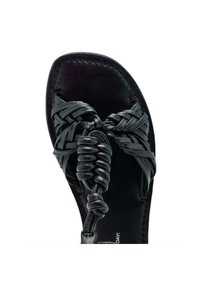 Sandale en cuir tressé noir avec des motifs tressés complexes sur le dessus, semelle plate et design minimaliste. Pas d'ornements supplémentaires.