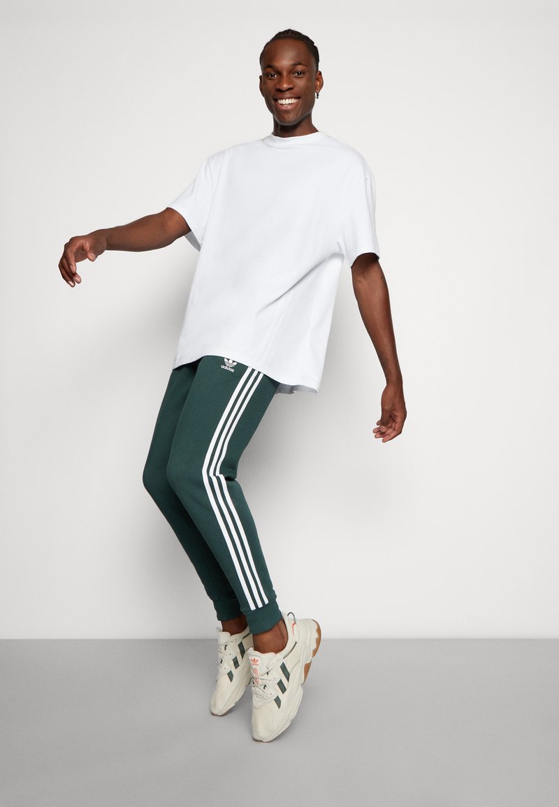 adidas Originals 3-STRIPES - Tracksuit bottoms - mineral green/dark green -