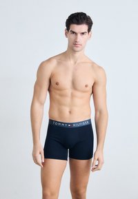 Boxeri din bumbac de culoare albastru marin cu un elastic personalizat care prezintă "TOMMY HILFIGER" în alb și un mic accent logo.