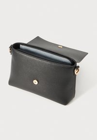 Pochette en cuir noir avec une finition texturée, garniture en or et fermeture éclair sécurisée. L'intérieur présente une doublure contrastante bleu clair.
