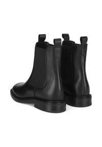 Czarne skórzane botki Chelsea z elastycznymi panelami bocznymi i pętlami do zakładania. Charakteryzują się gładkim wykończeniem i niskim, wsuwanym obcasem, zaprojektowane z myślą o łatwym zakładaniu.