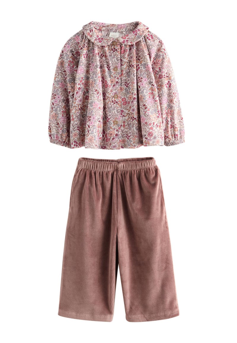 Virágmintás, könnyű anyagú blúz Peter Pan gallérral; puhán, rózsaszínű kordbársony culotte rugalmas derékpánttal.