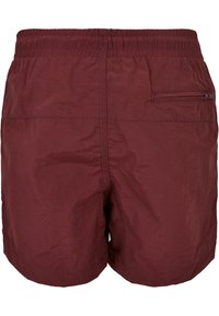 Shorts da bagno bordeaux con vita elastica, tessuto leggero e a rapida asciugatura, e una tasca con zip sul lato destro.