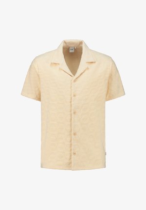 Košela s krátkym rukávom zo štruktúrovaného svetložltého materiálu, s geometrickým vzorom, výstrihom do "V" a piatimi prednými gombíkmi.