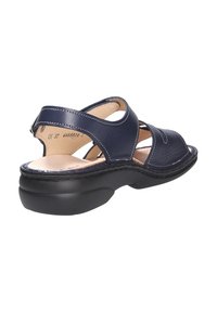 Donkerblauwe leren sandaal met kruisbandontwerp, open teen en gevoerde zwarte zool. Bevat stikselaccenten en een verstelbare achterband.