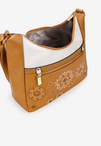 Bolso de cuero marrón claro con acentos blancos, costura decorativa y un bolsillo con cremallera en la parte frontal. El interior está forrado con una tela suave de color neutro.