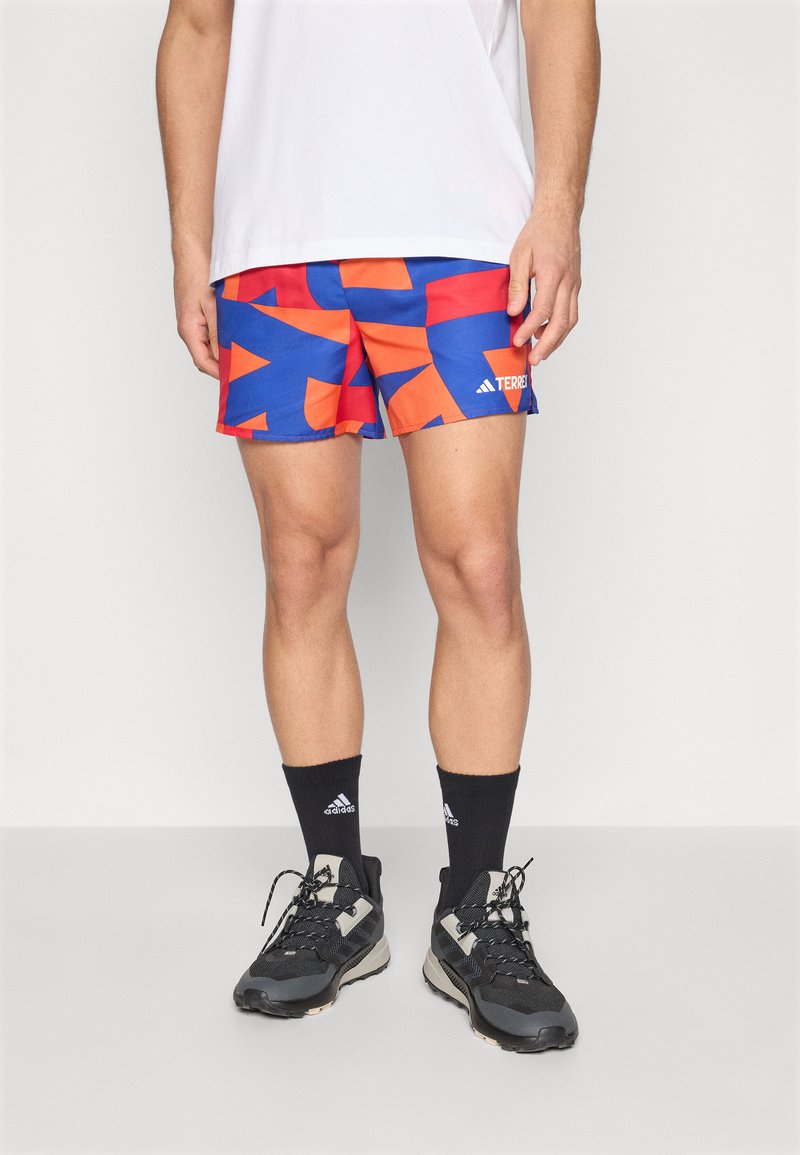 Athletic shorts featuring a vibrant blue and orange geometric pattern, lightweight fabric, elastic waistband, and a branded logo on the side.