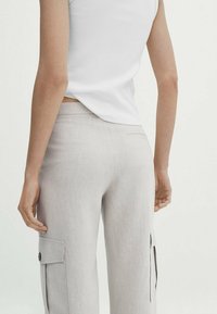 Lichtgrijze cargobroek met een slim fit, voorzien van zijzakken, een achterzak en een gladde, iets gestructureerde stof.