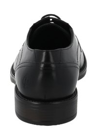 Scarpa da uomo in pelle nera vista da dietro, con dettagli cuciti, tacco basso e impilato, e un piccolo logo impresso sul tacco.