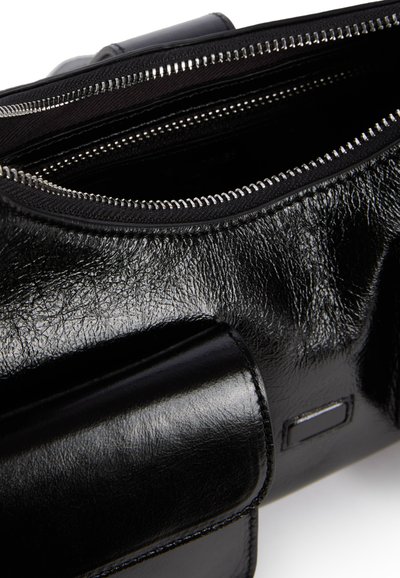 Borsa in pelle nera con finitura testurizzata, dotata di chiusura con zip e un accento liscio e lucido. Interno foderato in tessuto nero.