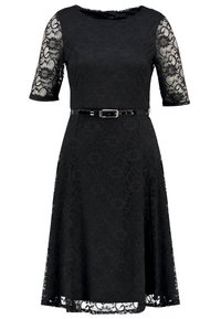 Musta pitsimekko, jossa on lyhyet kuviolliset hihat, vartalonmyötäinen vyötärö ja kiiltävä musta vyö. Hieman levenevä hame, joka päättyy polven alapuolelle.