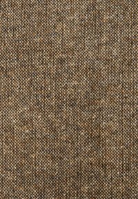 Tissu texturé aux tons terreux de marron et beige, présentant un motif tissé avec de petits fils serrés.