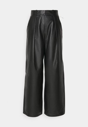 Pantalons en cuir noir à taille haute, avec une coupe large, présentant des plis et une texture lisse, conçus pour un ajustement décontracté.