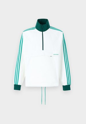 Casaco de pulôver branco com colarinho alto. Apresenta detalhes verdes, incluindo um fecho e três riscas verdes em cada manga.