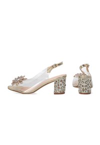 Klare åbne slingback sko med en guldfarvet accent, der har en blomstret rhinestones detalje, samt en dekorativ blokhæl med ædelstensmønstre.