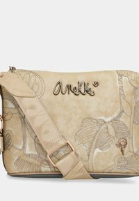 Borsa a tracolla beige con design floreale in rilievo; presenta un logo metallico, una tracolla regolabile e una chiusura a zip. Materiale leggero e texture liscia.