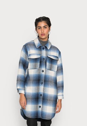 Veste chemise à carreaux bleus et blancs avec un col, deux poches poitrine et un devant boutonné. Fabriquée dans un tissu texturé au toucher doux.