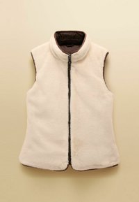 Krémová fleecová vesta s vysokým límcem, předním zipem a hnědým lemem. Měkká textura bez rukávů, vhodná na vrstvení.