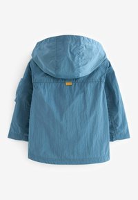 Ljust blå huva jacka tillverkad av texturerad tyg. Den har en gul accenttag nära halslinningen och en avslappnad passform.