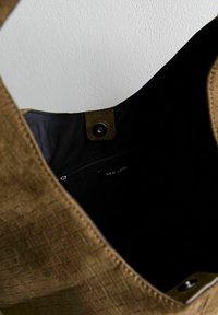 Borsa a spalla di colore marrone con texture, interno nero, chiusura a scatto magnetico e tasca interna con cerniera etichettata 'New Look'.