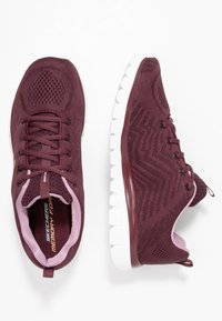 Baskets de sport bordeaux avec un dessus en tricot texturé, semelle en caoutchouc blanche et motif décoratif en zigzag. Comprend un système de laçage et une languette.