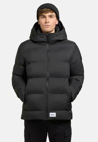 Sort polstret jakke med hætte, med en frontlynlås, sidelommer og et logo på kanten. Glat tekstur og varmt design.