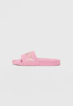 Pink slide sandals made of synthetic material, featuring a wide strap embossed with a metallic gold logo and a flat sole.