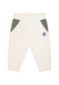 Crème-kleurige sweatpants met groene zijzakken, elastische tailleband en geborduurd logo. Zacht materiaal met een gladde textuur.