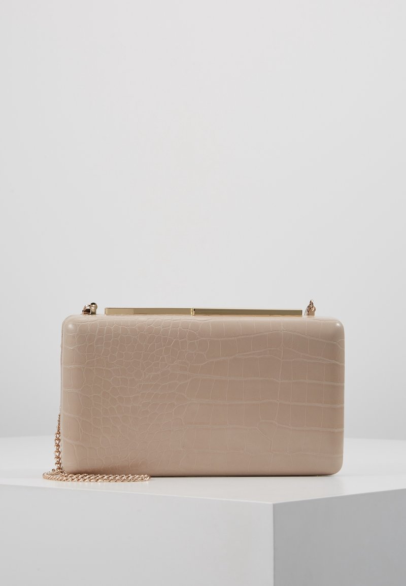 Pochette rectangulaire beige avec motif effet croco, fermoir doré et fine chaîne dorée sur une surface blanche.