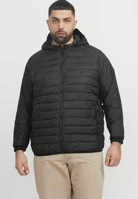 Black puffer jacket with a zip-front, textured quilted design, hood, and ribbed cuffs. Material appears lightweight and insulated.