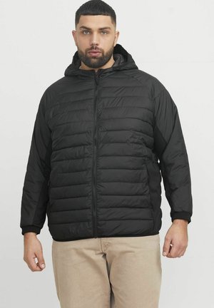 Chaqueta acolchada negra con cremallera en el frente, diseño de acolchado texturizado, capucha y puños acanalados. El material parece ligero y aislante.