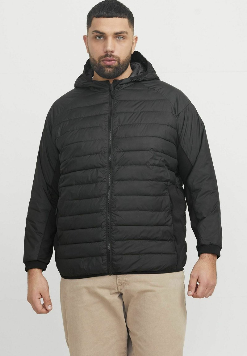 Black puffer jacket with a zip-front, textured quilted design, hood, and ribbed cuffs. Material appears lightweight and insulated.