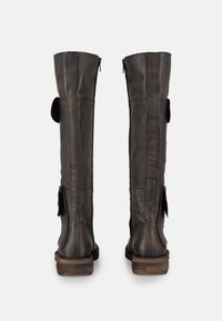 Botas altas de cuero negro con un acabado texturizado, cierre de cremallera y acentos laterales. Tacones de bloque de madera resistentes que mejoran la durabilidad y el soporte.