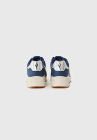 Baskets bleu marine avec un dos texturé, des accents en argent et une semelle de couleur claire. Elles sont dotées d'un col rembourré pour plus de confort.