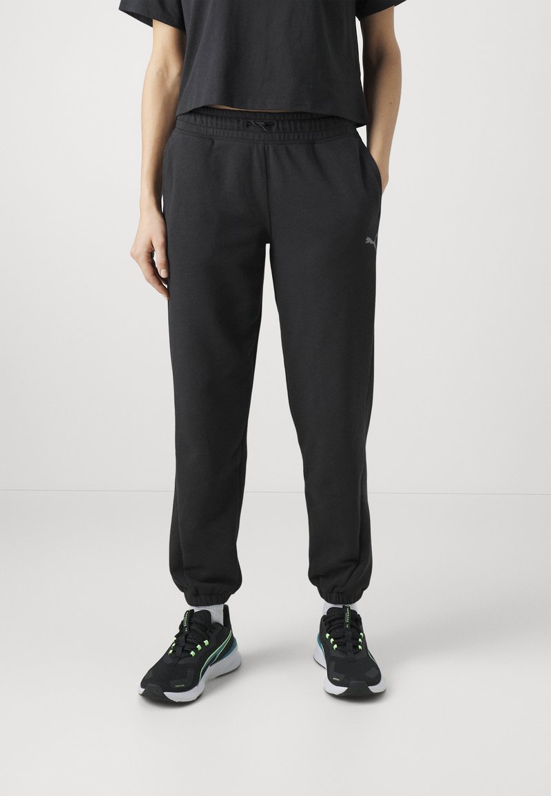 Zwarte katoenen sweatpants met taps toelopende enkels, een elastische tailleband, zijzakken en een klein logo op de linkerdij. In combinatie met zwarte sneakers.