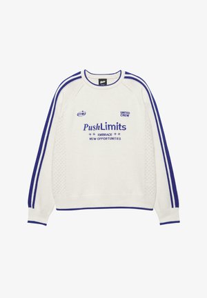Weißer, gestrickter Pullover mit blauen Streifen an den Ärmeln und blauem Text „Push Limits Embrace New Opportunities“ auf der Vorderseite.