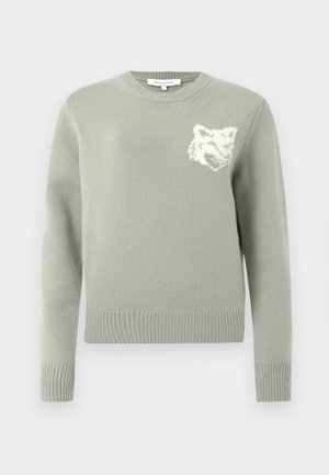 Jasnozielony sweter wykonany na drutach z okrągłym dekoltem, prążkowanymi mankietami i dołem, z białym wzorem wilka na piersi. Miękka tekstura.