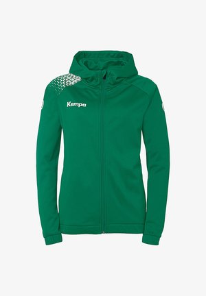 Hoodie vert à fermeture éclair fabriqué en tissu lisse, avec une capuche et un design géométrique texturé sur le haut à gauche. Logo "Kempa" blanc sur le devant.