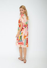 Blumenmuster-Kleid in sanftem Rosa mit bunten geometrischen Akzenten, kurzen Ärmeln, knielangem Schnitt und lässiger Passform.