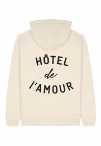 Felpa beige con cappuccio caratterizzata da un audace testo nero che recita "HÔTEL de l'AMOUR" curvato sulla schiena, con polsini e orlo a costine.