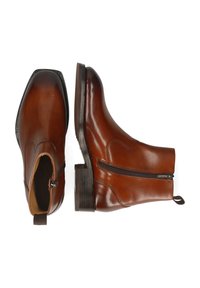 Stivaletti in pelle marrone con un design elegante, cuciture sottili, cerniere laterali e tacchi in legno. Texture liscia con una finitura lucida.