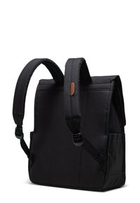 Zaino nero con spallacci imbottiti, forma rettangolare, tessuto testurizzato, tasche laterali e un'accento in pelle marrone sulla tracolla.