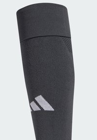 Calzino sportivo grigio con texture a coste e una ampia fascia, con dettaglio del logo a tre righe bianche vicino alla caviglia.