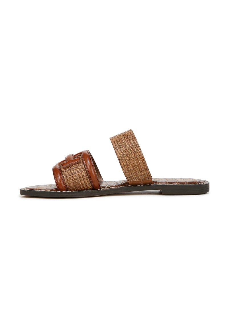 Bruine leren en geweven rieten schoen met een platte zool, met twee brede bandjes, waarvan één met een klein accentdetail.