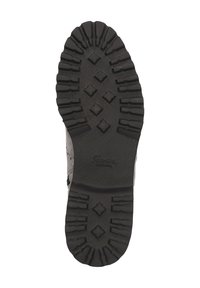 Semelle de chaussure en caoutchouc noir avec des rainures profondes, présentant un motif en losange et le logo de la marque embossé au centre. Texturée pour une meilleure adhérence.