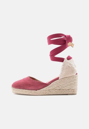 Kileespadrille med rosa stoffoverdel, beige flettet hæl, flettet juteplattform og lange rosa ankelremmer med tremerke.