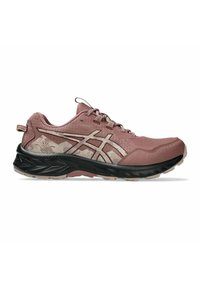 Zapatilla de trail running en rosa suave con acentos en beige, suela negra, parte superior de malla y diseño de cordones, mostrada desde el lado exterior.